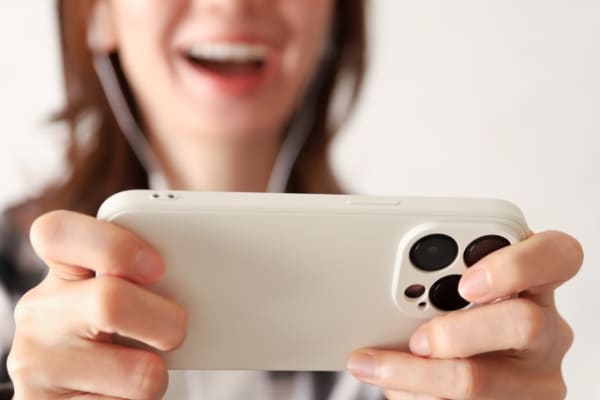 スマホでモバイルゲームをする女性の手元