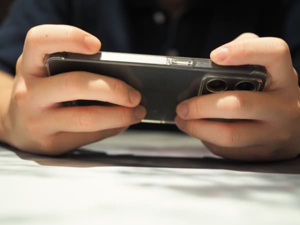 スマホでゲームする男性の手元