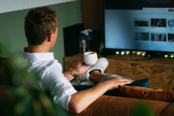 大画面テレビを見ている男